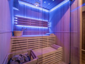 A sauna with wooden benches and a stone basin. - Spacious apartment with mountain view - 10 guests (La Plagne Montalbert)