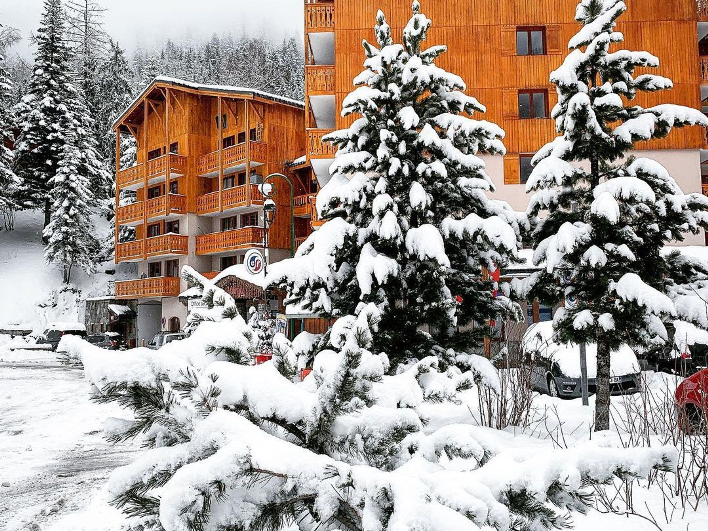 A wooden building with multiple balconies and a snow-covered landscape.
