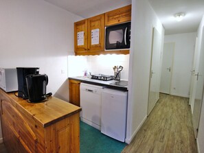 A compact kitchen with a microwave, coffee maker, and dishwasher. - Apartment, piste view - 6 guests (Villarodin-Bourget)