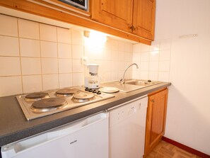 Eine Küche mit eingebautem Geschirrspüler, einer Kaffeemaschine und einem Spülbecken.