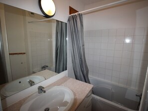 A bathroom with a sink, mirror, and bathtub. - Apartment pets, mountain view - 6 guests (Valfréjus)