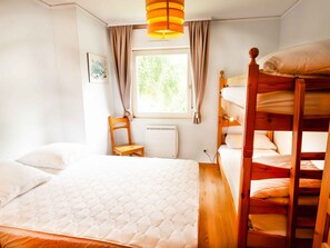 A room with a bunk bed, a single bed, a chair, a window with curtains, and a radiator. - Chalet with mountain view - 6 guests (Villarodin-Bourget)