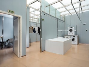 A hotel room with a bed, a desk, a chair, a washing machine, and a mirror. - Vienna Hotel Shenzhen Universiade Center (Shenzhen)