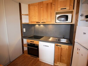 A compact kitchen with wooden cabinets, a microwave, a dishwasher, and a sink. - Spacious apartment, pets welcome - 6 guests. Park view (Villarodin-Bourget)