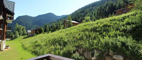A mountain landscape with houses and a wooden deck.