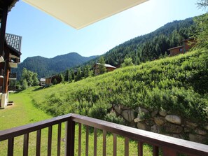 A mountain landscape with houses and a wooden deck. - Cozy apartment at the foot of the slopes - 4 guests (Valfréjus)