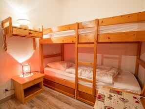 Ein Mehrbettzimmer mit Schreibtisch und Lampe.