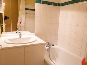 A bathroom with a white sink, a mirror, a shower, and a towel rack. - Apartment at the foot of the slopes - 4 guests (Valfréjus)