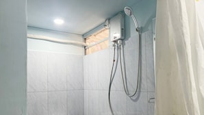 A bathroom with a toilet, a shower unit, and a sink. - Rock Sand Hostel (Koh Rong)