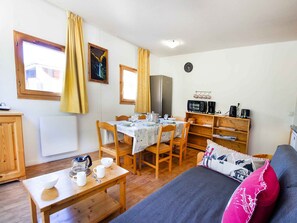 A cozy room with a dining table, chairs, a bed, a microwave, and a refrigerator. - Bright apartment with valley view - 6 guests (Villarodin-Bourget)