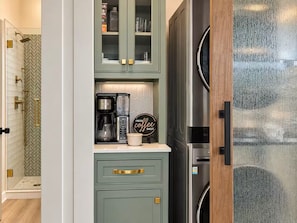 A kitchen with a coffee maker, cabinets, and a refrigerator. - Lakehaus at Water Edge -Modern Luxury/Beach/Dock/Kayaks/Fire Pit (Tracy City)