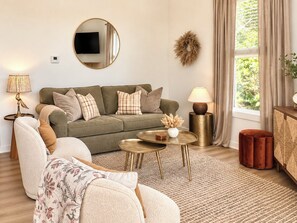 A living room with a sofa, armchairs, a coffee table, a TV, and a fireplace. - Lakehaus at Water Edge -Modern Luxury/Beach/Dock/Kayaks/Fire Pit (Tracy City)