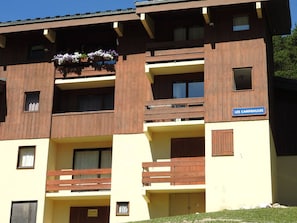 A multi-story building with balconies, a sign reading 'LES CAMPANULES,' and a sign indicating 'A LOUER' on the ground floor. - Apartment, pets allowed - 6 guests near the forest (Villarodin-Bourget)