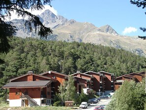 Reihe von Holzhütten mit Blick auf die Berge.