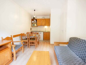 A compact living space with a dining area, kitchenette, and a sofa. - Apartment with lovely Vanoise park view - 4 guests (Valfréjus)