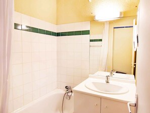 Ein Badezimmer mit einer Badewanne, einem Waschbecken und einem Spiegel.