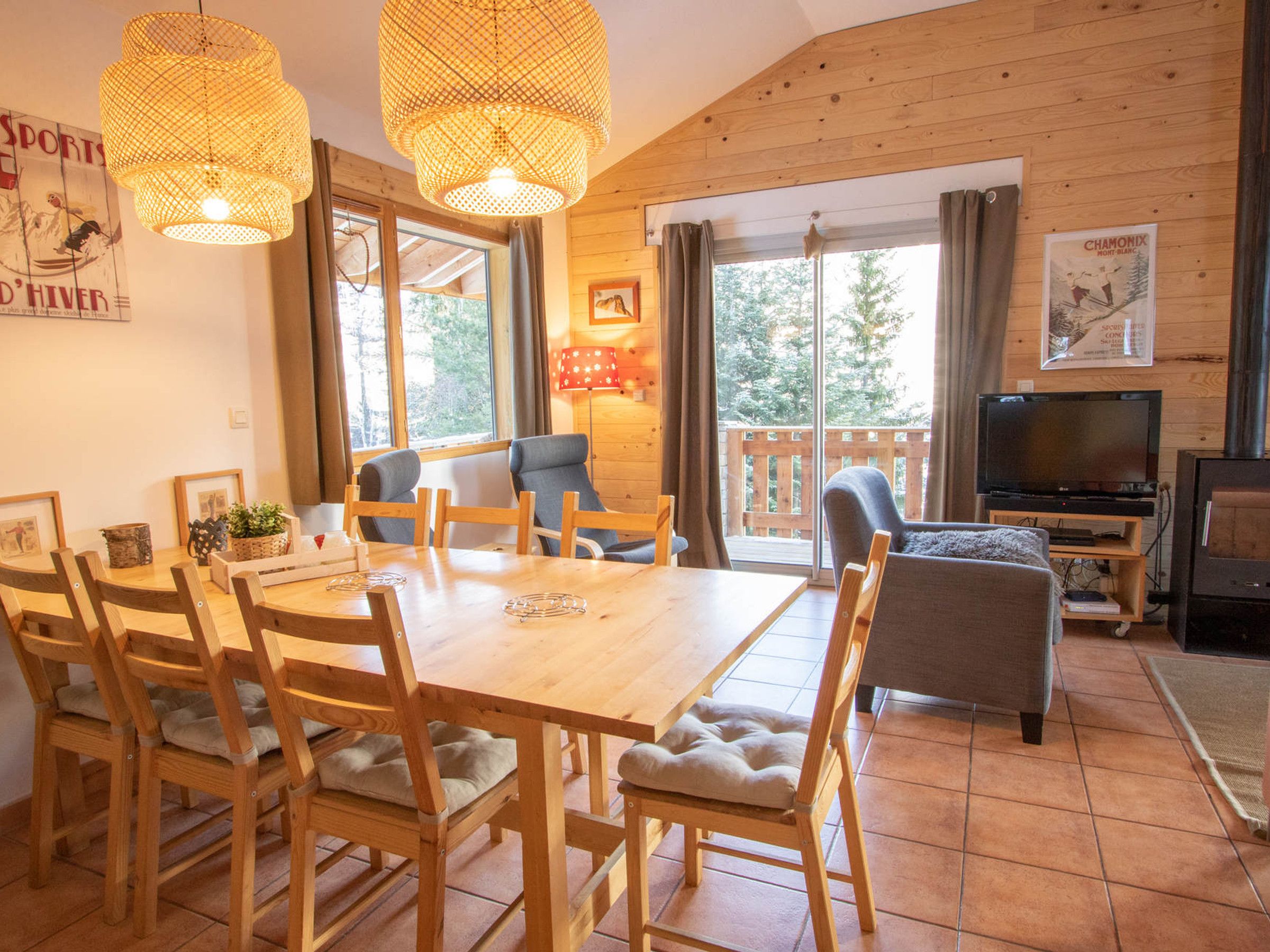 Un interno in legno con un tavolo da pranzo, sedie, un divano, una televisione e un caminetto.