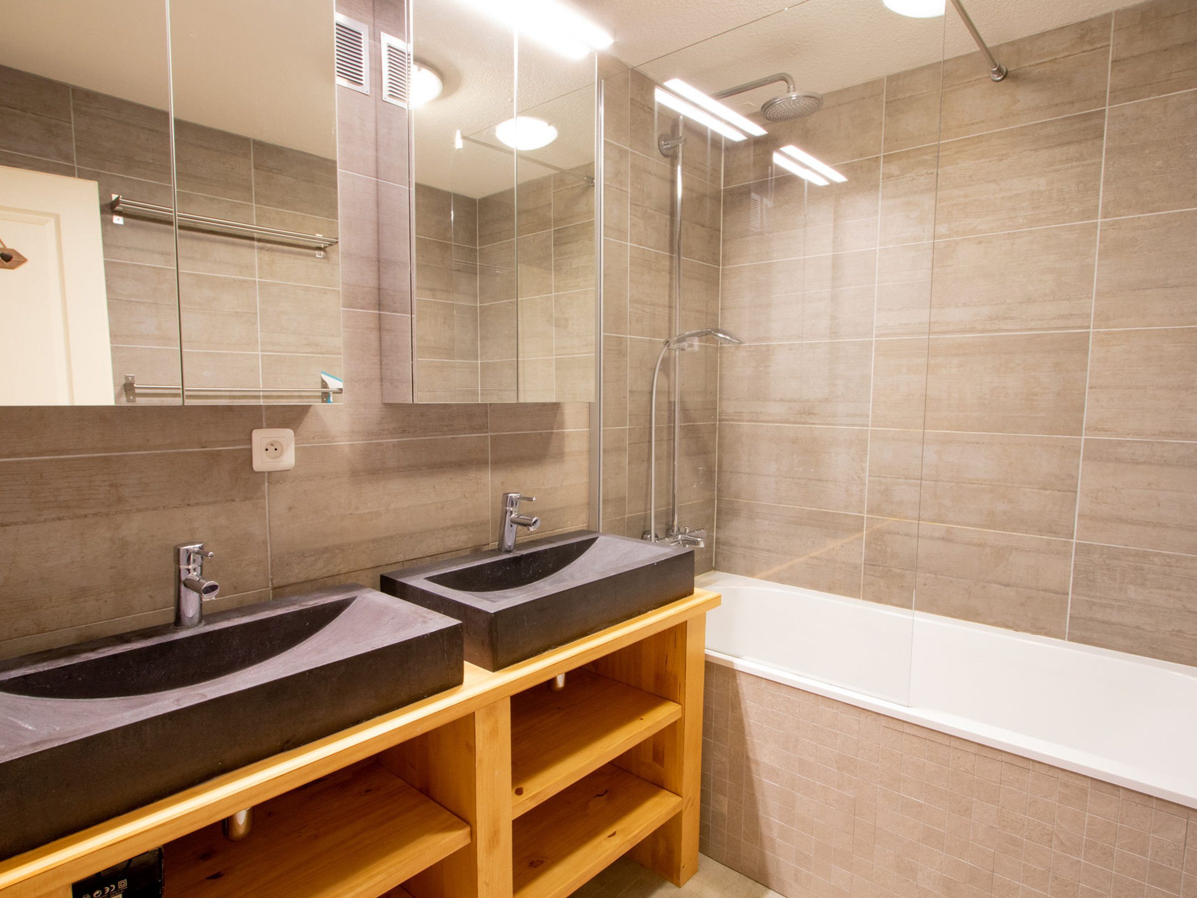 Un bagno moderno con due lavandini, una doccia e una vasca da bagno.