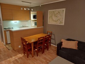 A compact living space with a kitchenette, dining area, and a sofa. - Apartment by the slopes, pets allowed - 8 guests (Villarodin-Bourget)