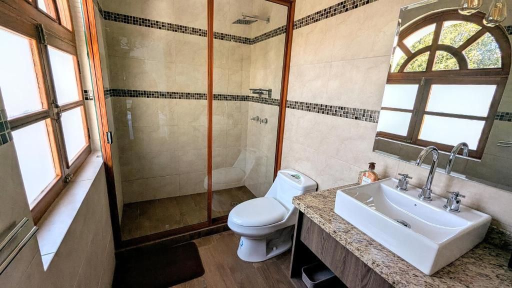 Un baño con inodoro, lavamanos y ducha.