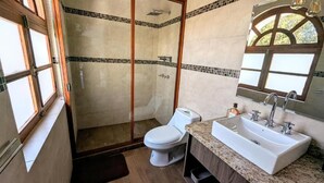 Een badkamer met toilet, wastafel en douche.