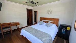 A bedroom with a bed, bedside table, and a desk. - La Casona Emma Rooms (Quito)