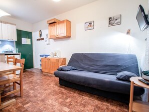 Ein gemütlicher Wohnbereich mit einer Couch, einem Esstisch und einer Küchenzeile.