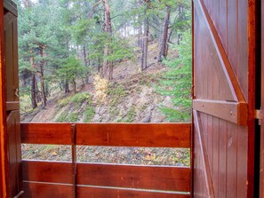 Eine Holzhütte mit Blick auf einen bewaldeten Hügel.