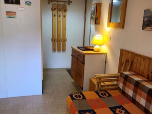 A compact room with a bed, a small desk with a lamp, a wooden cabinet, and a ski rack against the wall. - Charming apartment at the foot of the slopes - 4 guests (Villarodin-Bourget)