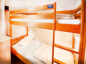 A bunk bed with a wooden frame and white bedding. - Practical studio near the slopes - 4 guests (Villarodin-Bourget)