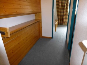 A narrow hallway with wooden paneling on the walls and a carpeted floor. - Studio mountain view, pets welcome - 3 guests (Valfréjus)