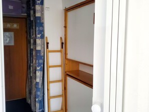 A narrow hallway with a wooden ladder leaning against a wall, a door with a sign, and a curtain with a deer pattern. - Studio with massif view - 3 guests (Valfréjus)