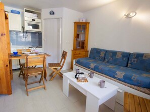 A compact living space with a kitchenette, a dining table with chairs, a sofa, and a coffee table. - Studio with massif view - 3 guests (Valfréjus)