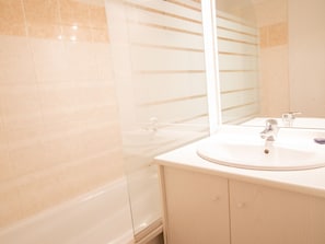 A bathroom with a bathtub, a sink, and a mirror. - Charming apartment, mountain view - 6 guests (Valfréjus)