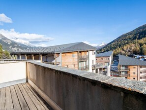 Ein Holzhaus mit Balkon mit Blick auf eine Berglandschaft.