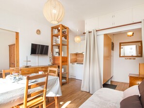 A modern, well-lit room with a dining area, a kitchen, and a living space. - 2-room apartment with balcony - 4 guests (Villarodin-Bourget)