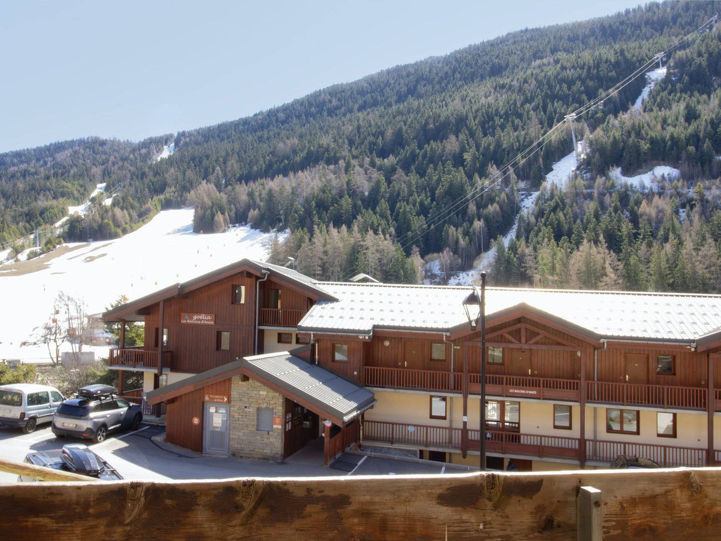 A wooden lodge with a ski slope in the background.