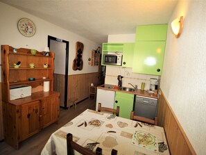 A compact kitchen with wooden cabinets, a microwave, and a sink. - Studio cabin at the edge of the woods - 4 guests (Villarodin-Bourget)