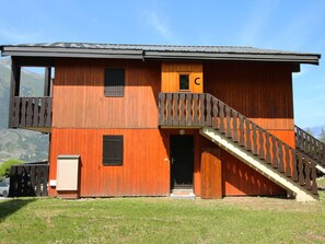 Ein zweistöckiges Holzgebäude mit einem Balkon und einer Treppe zum Eingang.