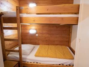 A bunk bed with a wooden frame and two beds. - Apartment mountain view, pets OK - 6 guests (Villarodin-Bourget)