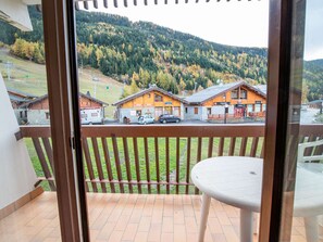 A balcony with a view of a mountain, a wooden fence, and a table. - Comfortable apartment, pets welcome - 4 guests (Villarodin-Bourget)