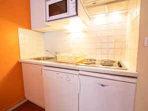 A compact kitchen with a dishwasher, a microwave, and a stove. - Comfortable apartment, pets welcome - 4 guests (Villarodin-Bourget)