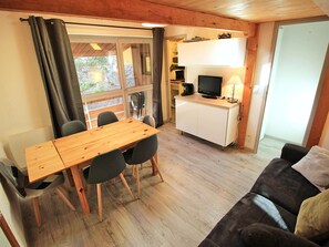 A compact living space with a dining area, a kitchenette, and a seating area. - Renovated apartment - 7 guests, forest edge (Villarodin-Bourget)