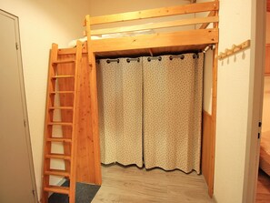 A room with a wooden bunk bed, a ladder, and a door leading to another room. - Renovated apartment - 7 guests, forest edge (Villarodin-Bourget)