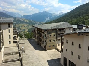 A multi-story building with balconies and a view of a mountainous landscape. - Apartment pets welcome - 6 guests, mountain view (Villarodin-Bourget)