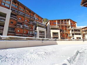 A multi-story building with balconies, a snow-covered ground, and a clear sky. - Charming apartment at the foot of the slopes - 4 guests (Villarodin-Bourget)