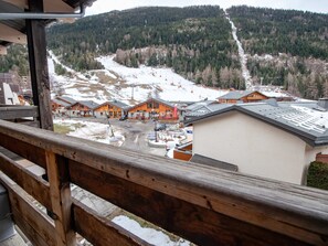 A mountain resort with wooden buildings, a ski slope, and a view of the surrounding forest. - Apartment mountain view - 6 guests (Villarodin-Bourget)