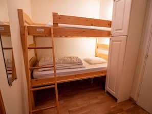 A bunk bed with a lower bunk, a mattress, pillows, and a wooden ladder. - Apartment mountain view - 6 guests (Villarodin-Bourget)