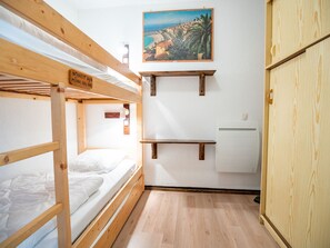 A bunk bed room with a painting, a small shelf, and a wardrobe. - Studio, mountain view - 4 guests (Villarodin-Bourget)