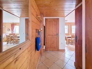 A wooden interior hallway with a dining area visible through an open door. - Spacious apartment with balcony and parking, close to slopes - 6 people (Les Menuires)